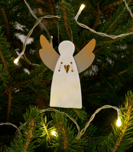 Petit ange gardien en porcelaine blanche, motif coeur et ailes en papier.Il est fixé à un cordon en métal doré.Objet poétique, il saura trouver sa place sur votre sapin de Noël.