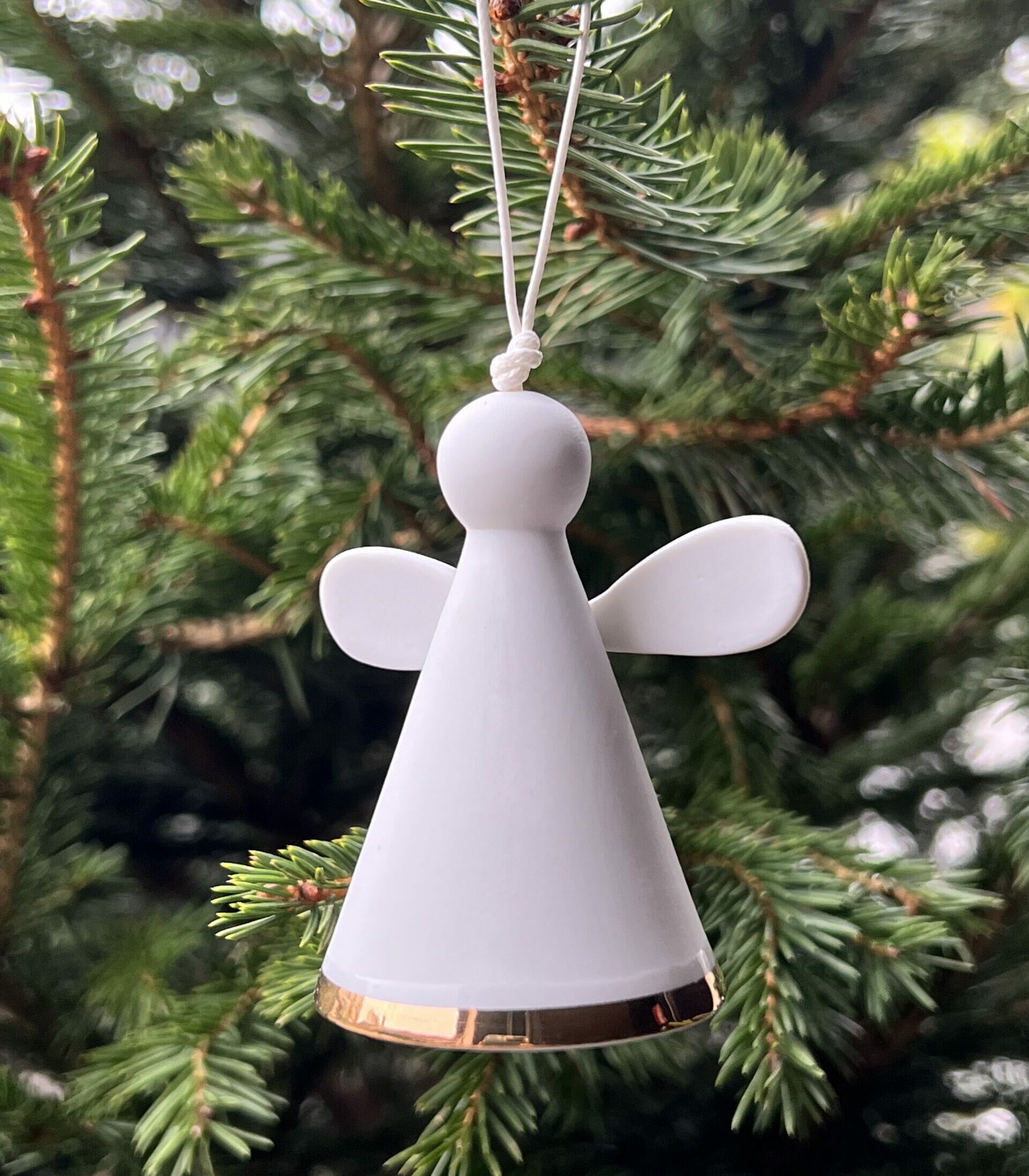 Petit ange gardien en porcelaine blanche,Il est équipé d’une petite clochette pour accompagner l’esprit joyeux des fêtes de fin d’année. Objet poétique, il saura trouver sa place sur votre sapin de Noël.