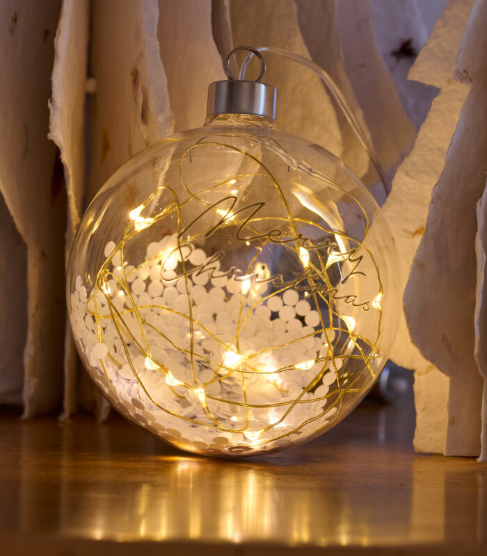 Sublimez votre décoration de Noël avec cette magnifique boule de Noël en verre remplie de paillettes argentées et d’une guirlande LED à l’intérieur. Message “Merry Christmas” sur la boule en verre